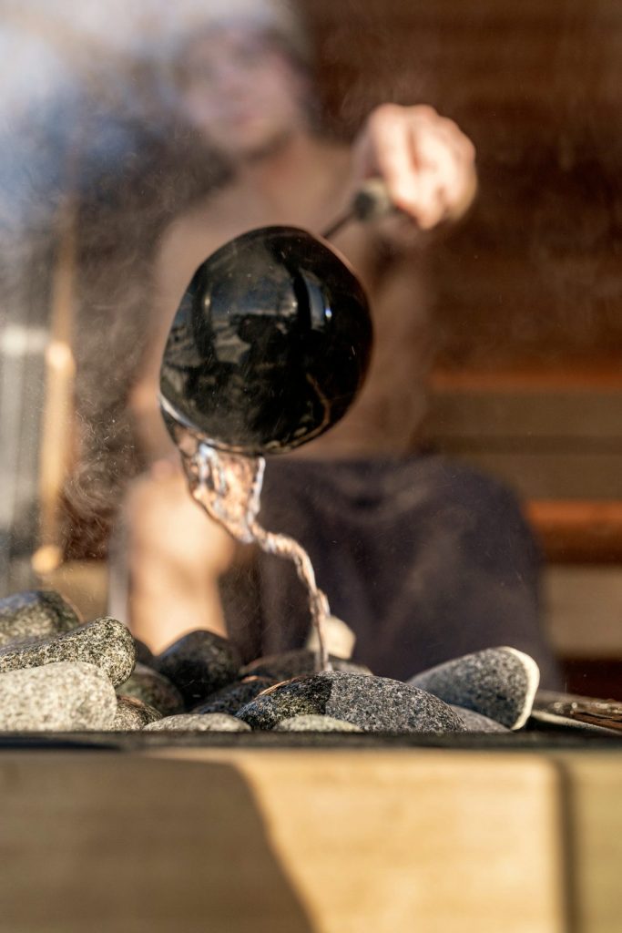 Water poured on hot sauna stones, steam rising